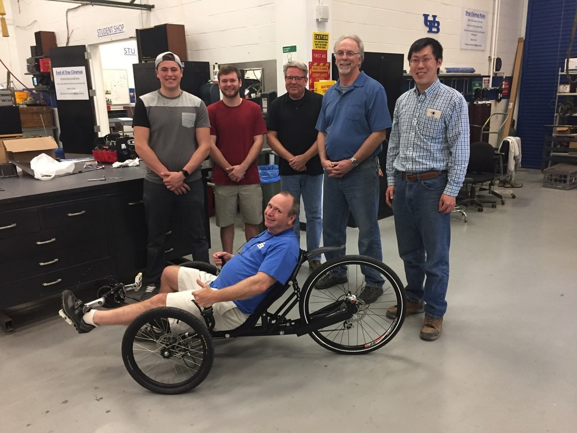 Curt Senf on his trike with UB students Caleb Walters and Austin Powers and Machine Shop staff William Macy, Gary Olson and Xinnan Peng. 