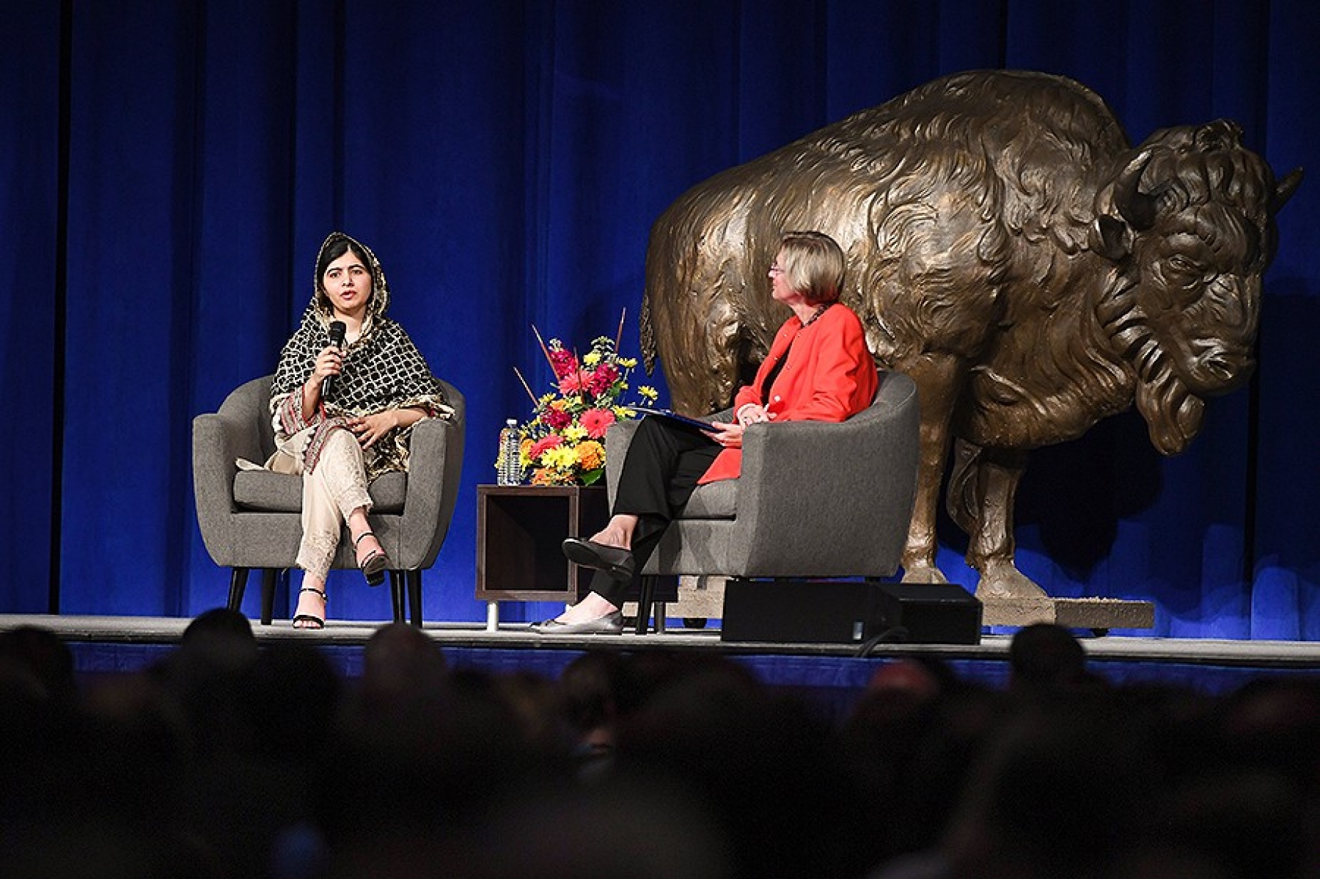 Malala Yousafzai sitting on Alumni Arena stage with Liesl Folks, engineering dean and discussion moderator. 