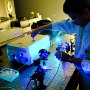 Environmental shot of a person adjusting a laser in the Lasers, Photonics and Bio-photonics Lab of Chemistry, Physics, Medicine & Electrical Engineering UB Distinguished Professor Paras Prasad. 