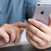 Male hand holding an iPhone. 