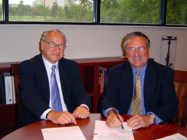 Athenex co-founder Allen Barnett UB&rsquo;s Robert Genco signing the deal that allowed Athenex to license discoveries made in the lab of UB researcher and Athenex co-founder David Hangauer. 