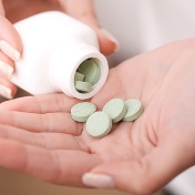 woman pouring fiber supplements from a bottle into her hand. 