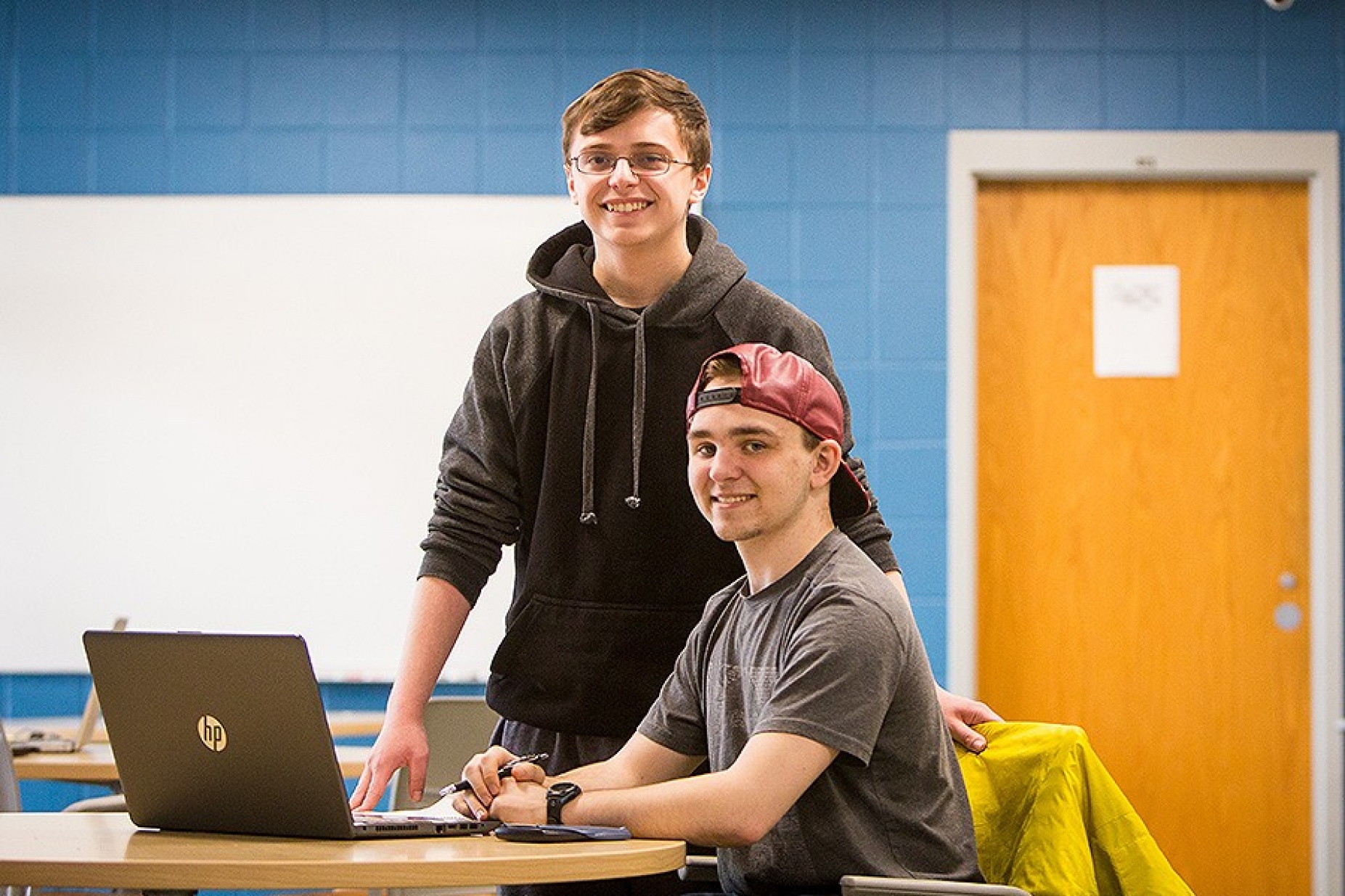 Isaac Rezey and Matthew Weinberg, president and vice president, respectively, of EMERGE, pictured together with a laptop computer in a classroom setting. 