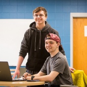 Isaac Rezey and Matthew Weinberg, president and vice president, respectively, of EMERGE, pictured together with a laptop computer in a classroom setting. 