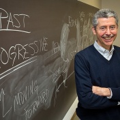 Timothy Cauller, program director for English as a Second Language Instruction, in front of a blackboard in a classroom in Baldy Hall. 