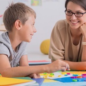 A happy student works with an encouraging teacher. 