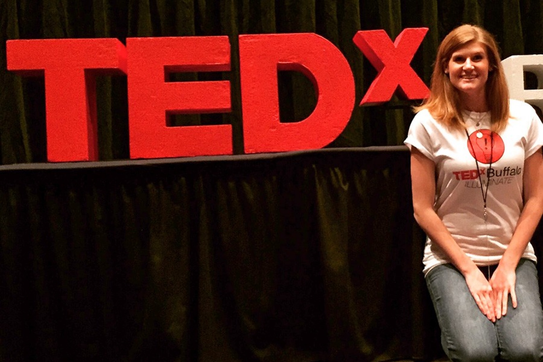 Lauren McGowen poses next to the TEDx letters. 