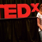 Lauren McGowen poses next to the TEDx letters. 