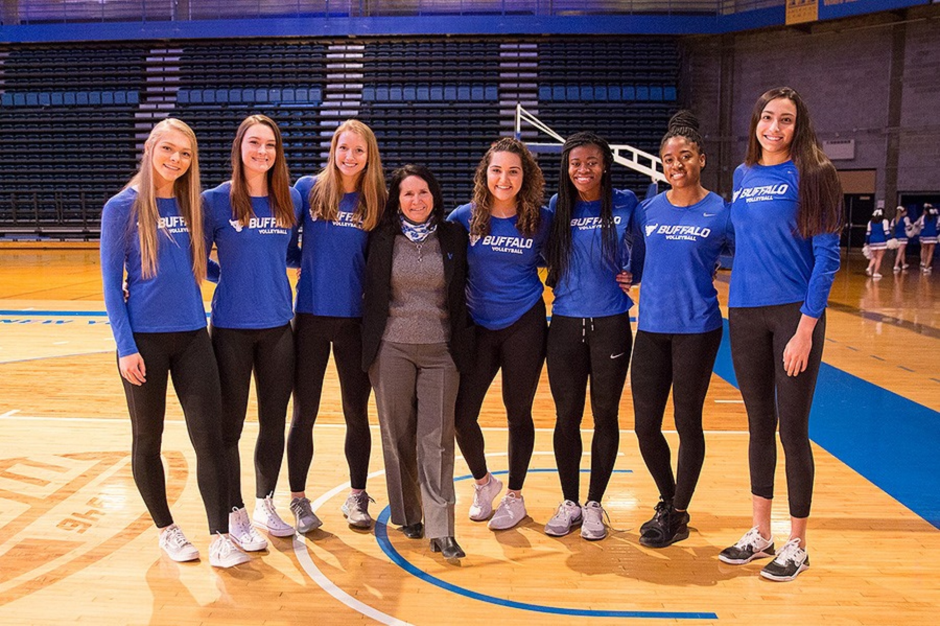 Kathy Twist poses with members of the women's volleyball team. 