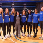 Kathy Twist poses with members of the women's volleyball team. 