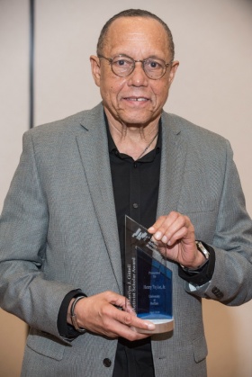 Henry Louis Taylor Jr. holding the Marilyn J. Gittell Activist Scholar Award. 