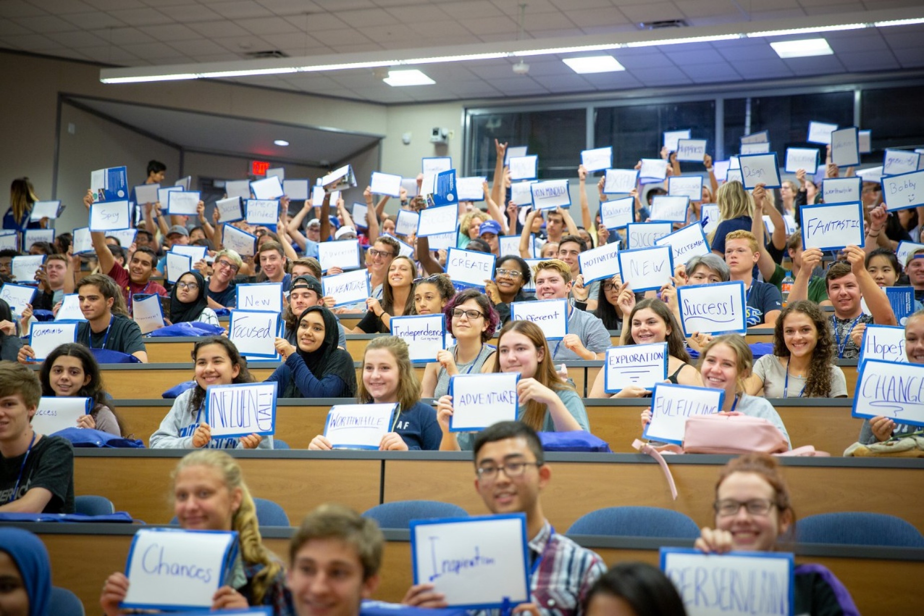 students at orientation holding signs that feature the words defining their upcoming experience at UB.