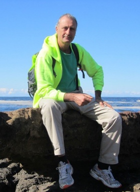 photo of Simon Penny sitting on a boulder. 