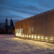 nighttime view of Light/Station, with twin towers of St. Stan's church in the background. 