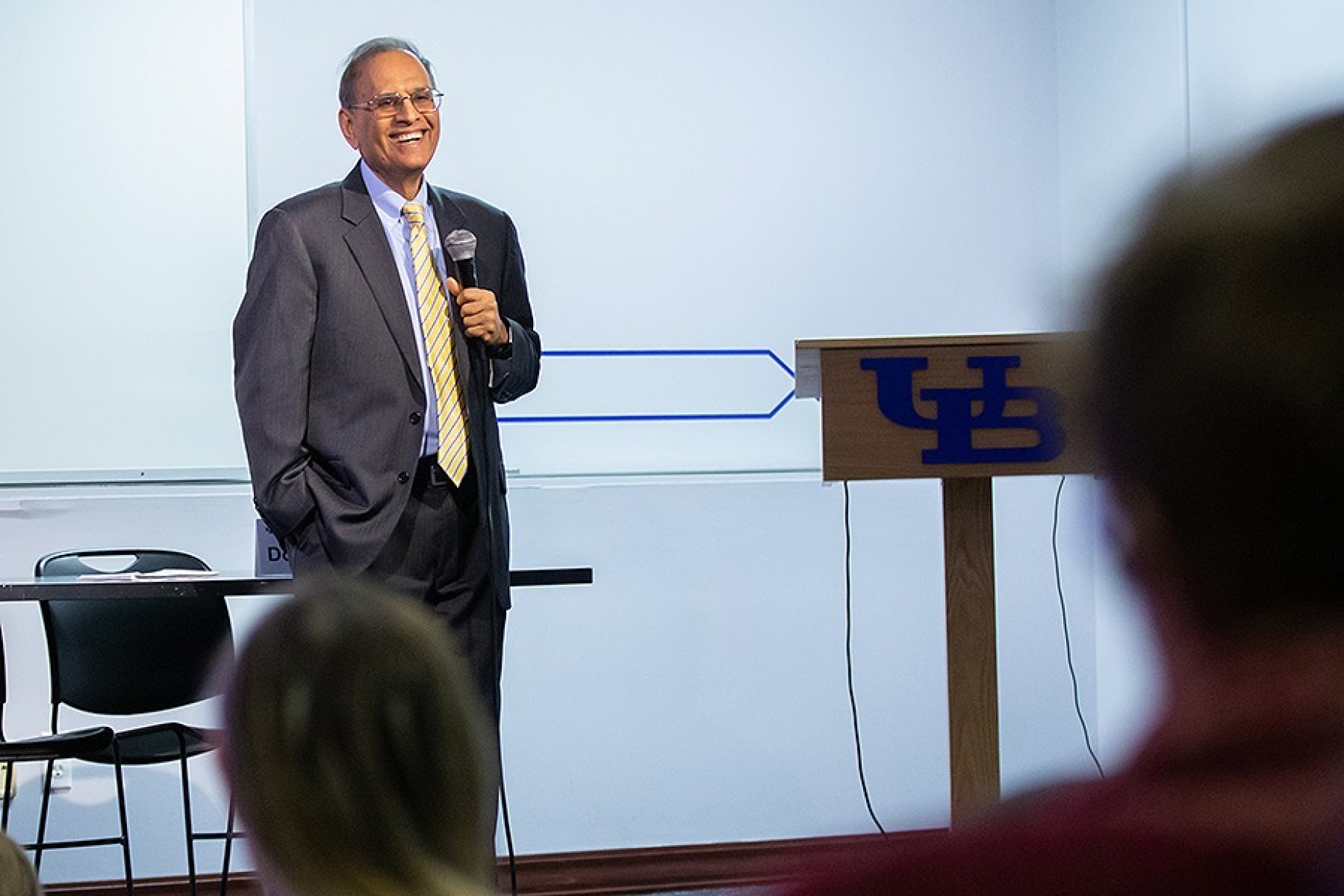 President Tripathi stands with a mic in hand during his annual visit to the Professional Staff Senate.