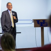 President Tripathi stands with a mic in hand during his annual visit to the Professional Staff Senate. 