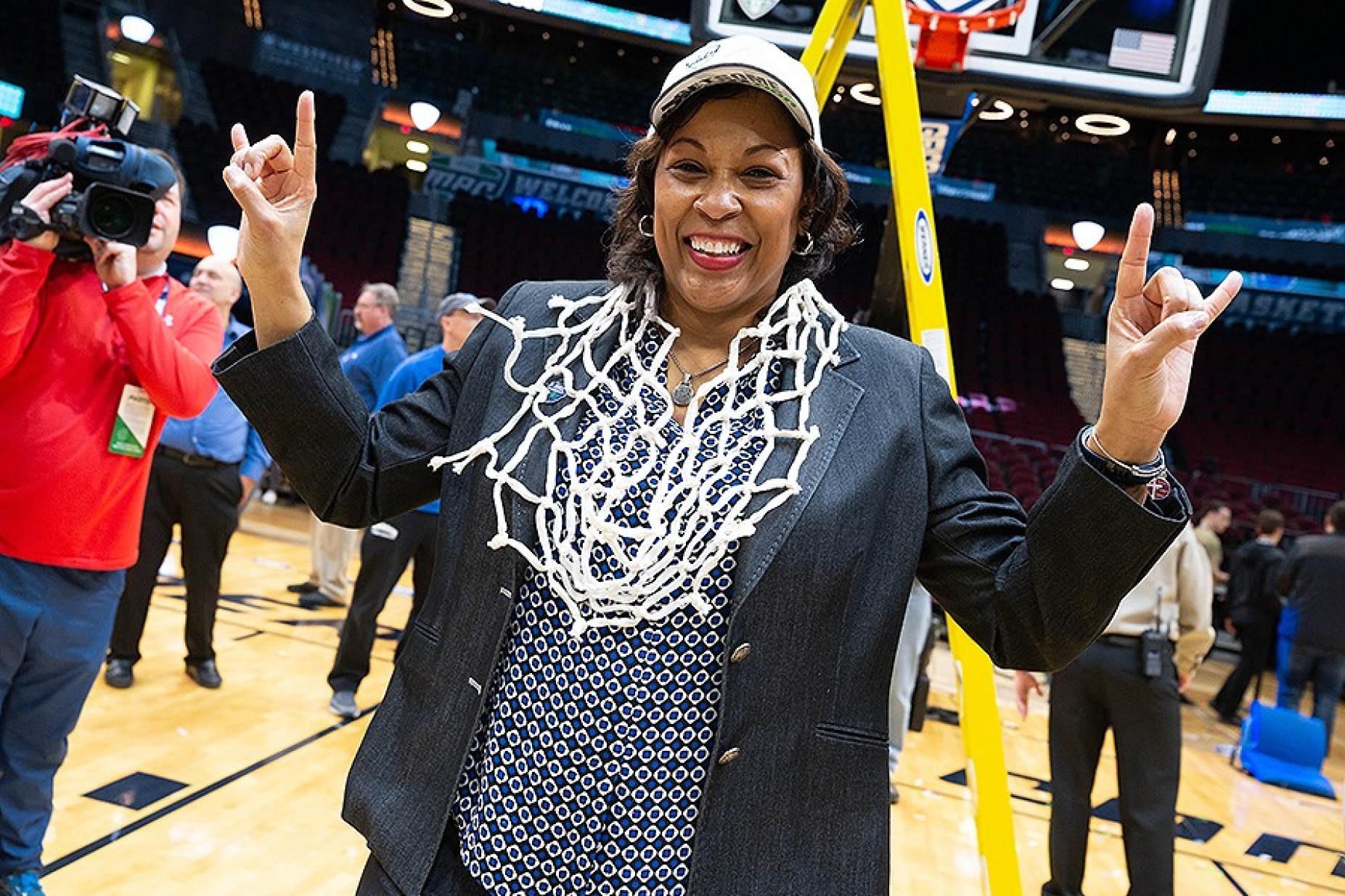 Coach Jack celebrates the team's win by wearing the game net around her neck after it was cut down. 