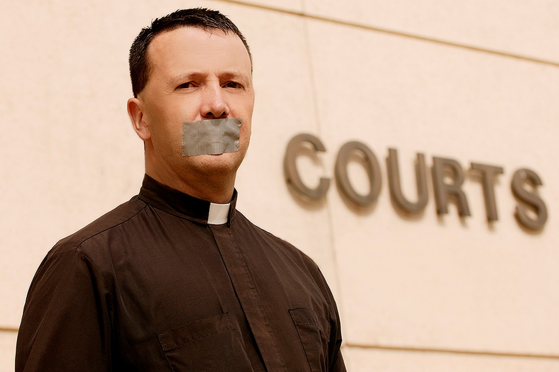 Concept of clergy privilege: a priest with tape over his mouth stands in front of a building with the word "courts" on the side. 