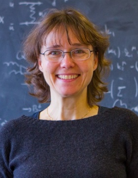 Doreen Wackeroth standing in front of a blackboard covered with mathematics formulas. 