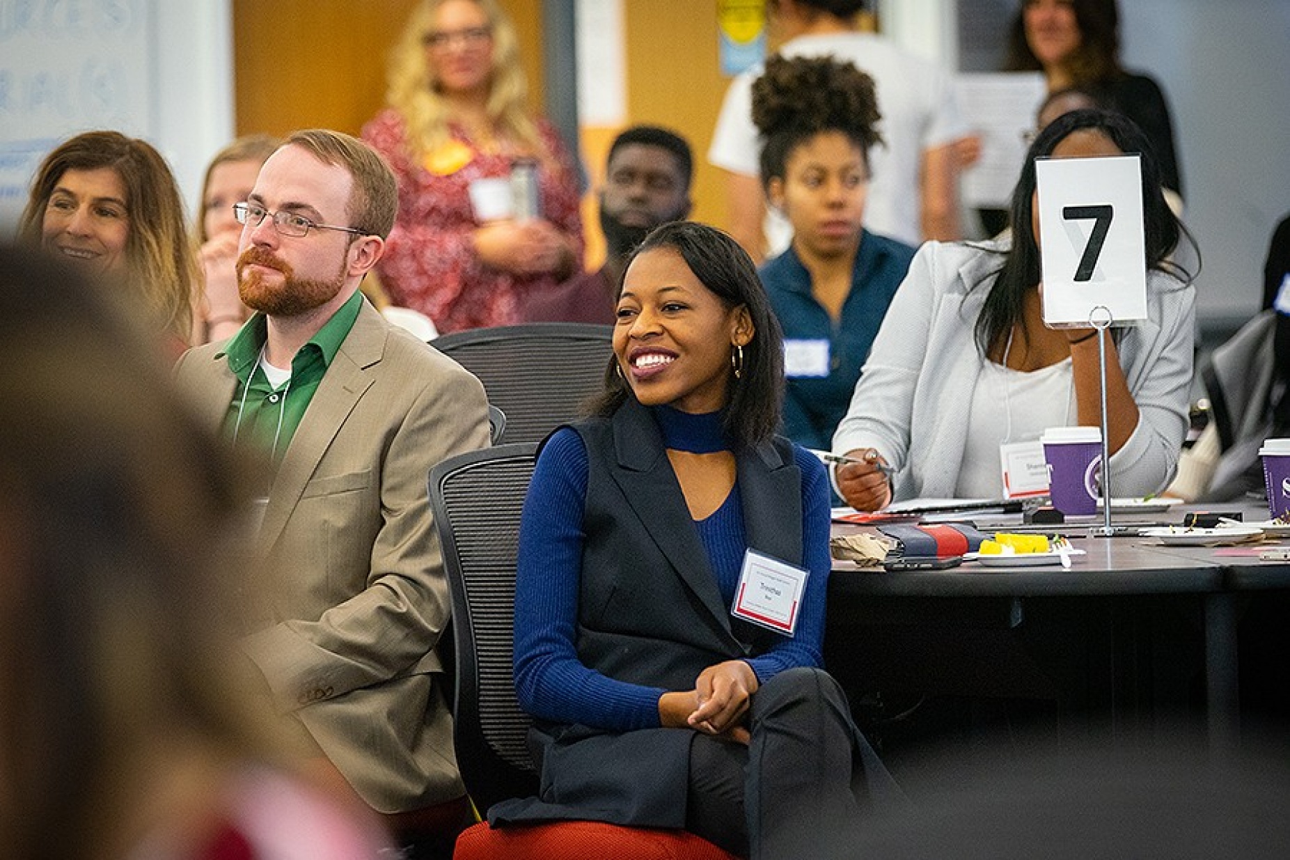People in an audience listening to a panel discussion.
