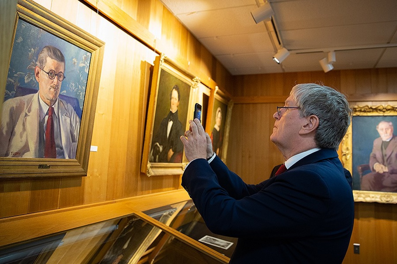 Daniel Mulhall, Ambassador of Ireland to the United States, photographs a portrait of James Joyce that is part of the UB James Joyce Collection. 