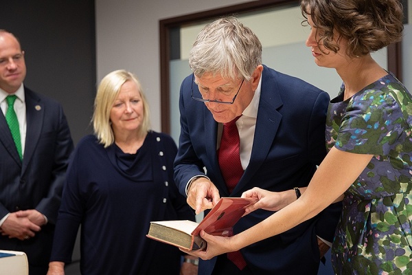 Zoom image: Daniel Mulhall, Ireland&rsquo;s ambassador to the U.S., examines a book that is part of UB&rsquo;s James Joyce Collection. With Mulhall are, from left, state Sen. Tim Kennedy; Greta Mulhall, Daniel Mulhall&rsquo;s wife; and Alison Fraser, assistant curator of UB&rsquo;s Poetry Collection. Photo: Meredith Forrest Kulwicki 