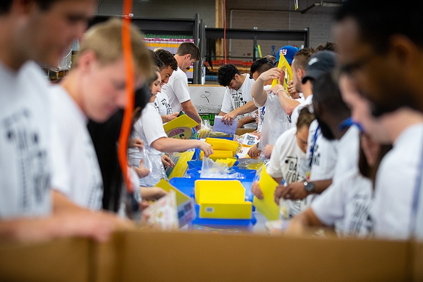Volunteers from the School of Management organize and package school supplies for the Teacher's Desk in Buffalo, NY as part of UB Day of Caring in August 2019. 