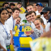 Students smiling as they work at The Teacher's Desk warehouse during Day of Caring. 