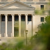 A student sits on the stairs of Abbott Library on a summer day. 