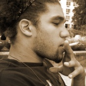 A young African-American man smokes a cigarette. 