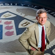 Charles Zukoski standing on the UB seal on the floor of the Student Union lobby. 