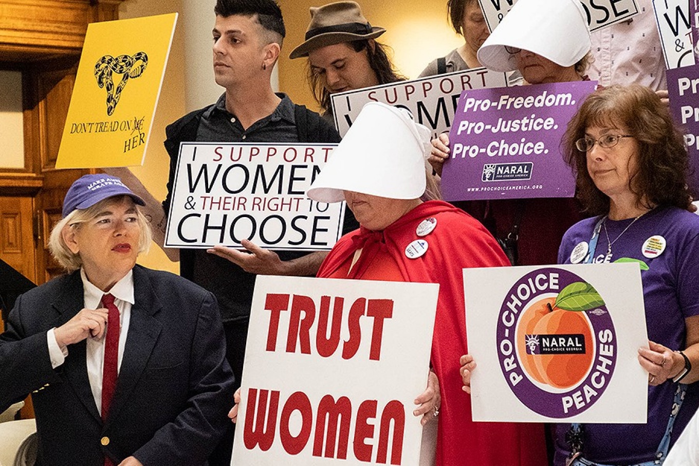 Pro-choice demonstrators with signs at a May 2019 Planned Parenthood forum. 