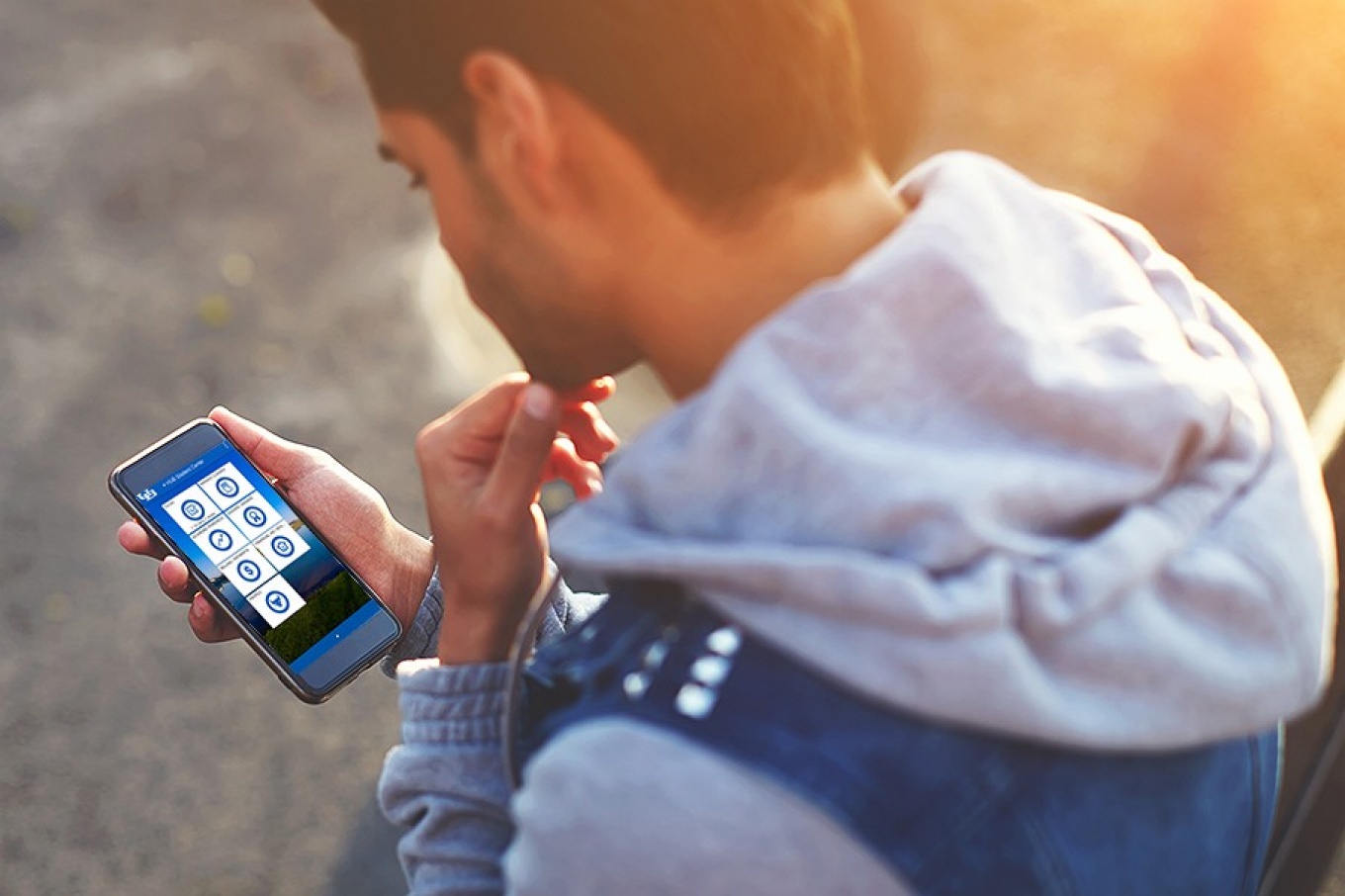 A student looking at a mobile device with the HUB site displayed on the screen. 