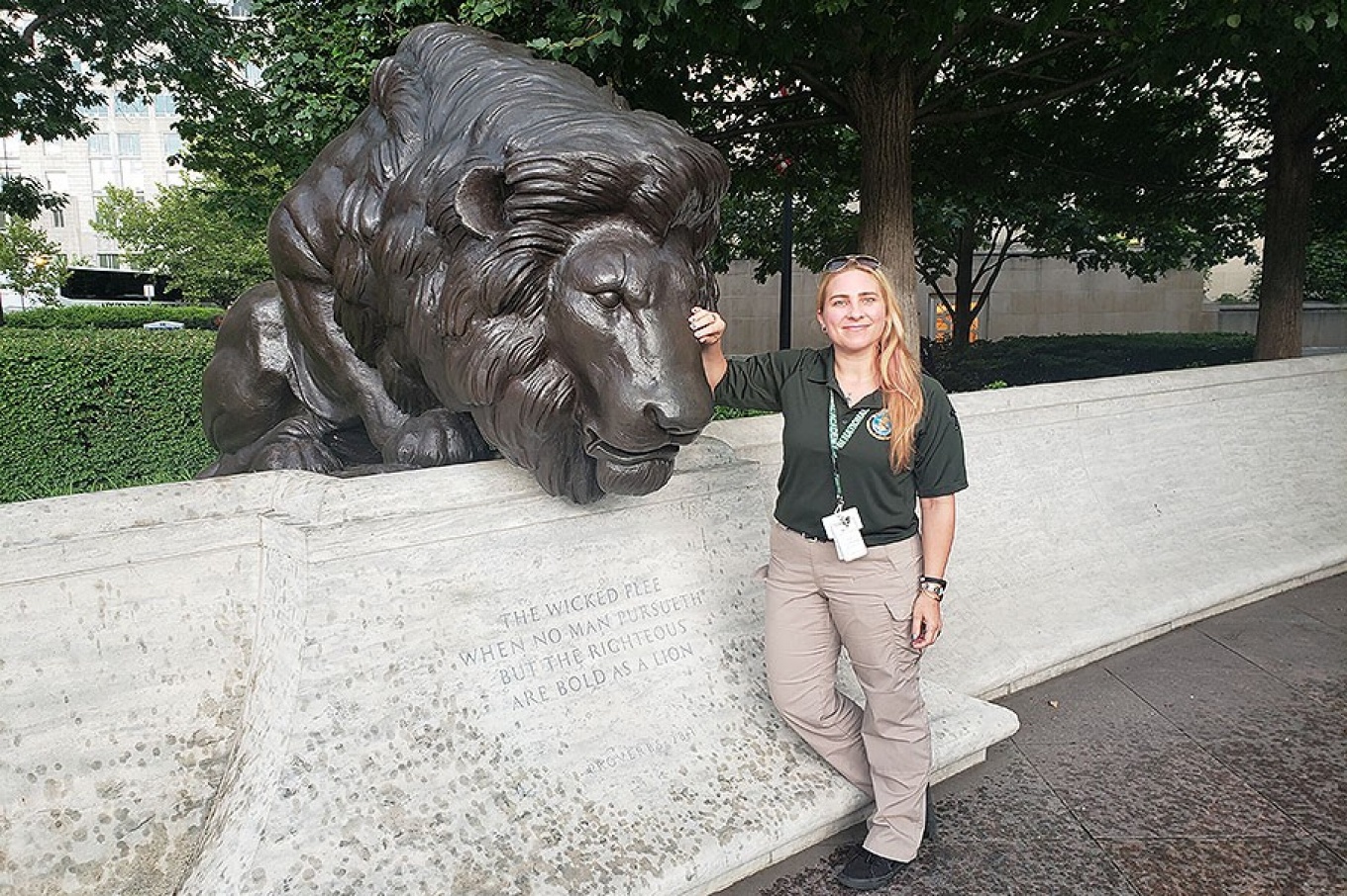 Zoom image: Stacy Tuberdyke and her classmates at the National Academy traveled to the National Law Enforcement Memorial in Washington, D.C. Here, Tuberdyke poses with a lion sculpture honoring fallen law enforcement officers. Photo: Courtesy of Stacy Tuberdyke 