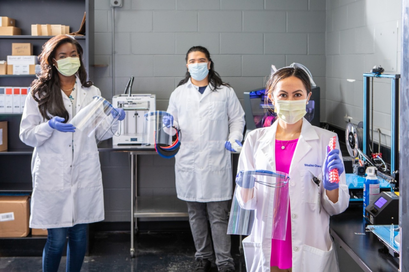 Zoom image: From left: UB students Joycelyn Moss, Philip Sales and Shaina Chechang hold PPE materials that they, along with a team of other students, created for local dentists. Photo: Douglas Levere 