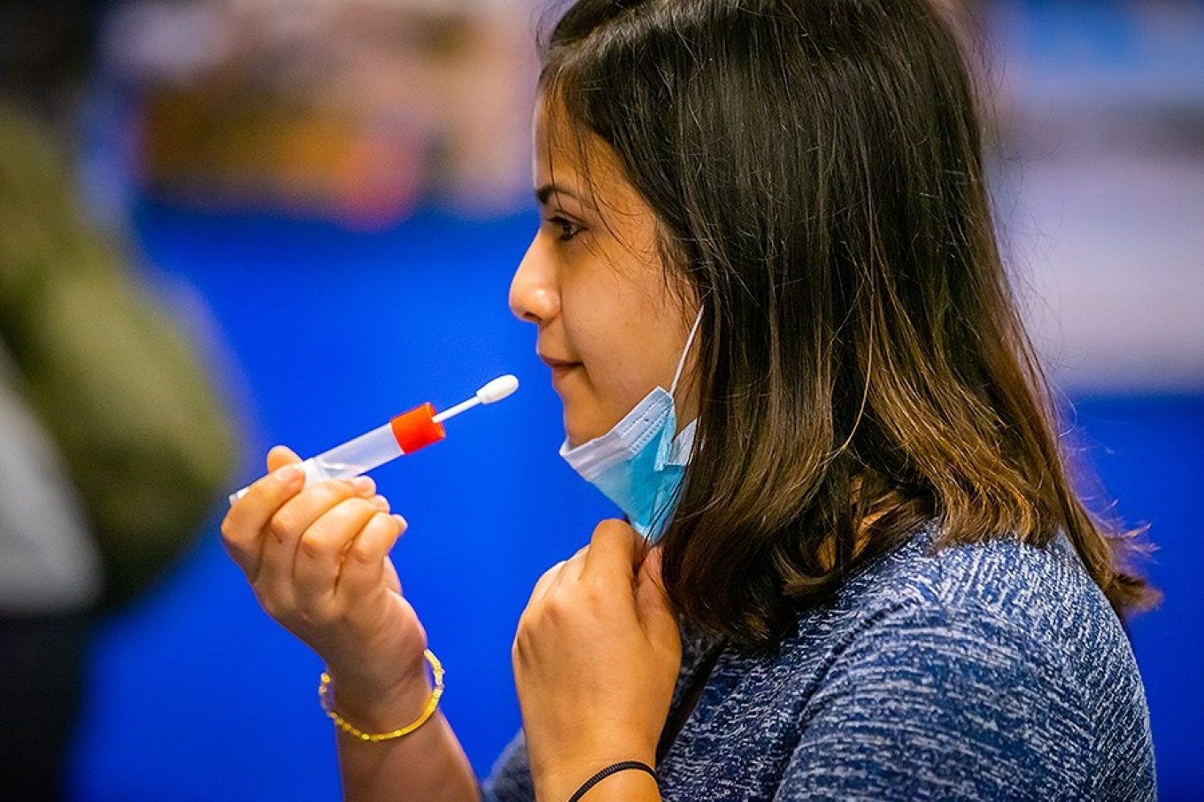 A student prepares to use a swab to collect a sample during surveillance COVID testing. 