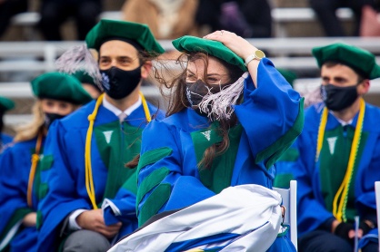 Zoom image: The wind was fierce during the Jacobs School commencement, leaving many graduates hanging onto their hats. 