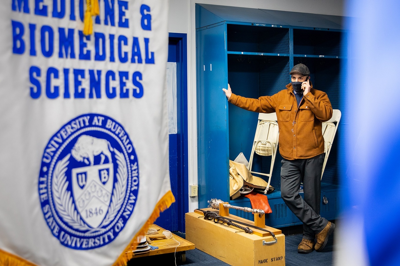 Zoom image: Doug Borsuk, logistics manager with Event Planning and Services, reviews with a co-worker the same-day to-do list ahead of the Jacobs School of Medicine and Biomedical Sciences’ commencement ceremony on April 30. Photos and essay: Meredith Forrest Kulwicki 