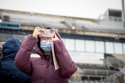Zoom image: Lei Zhu of the School of Management takes photos on her phone for reference. 