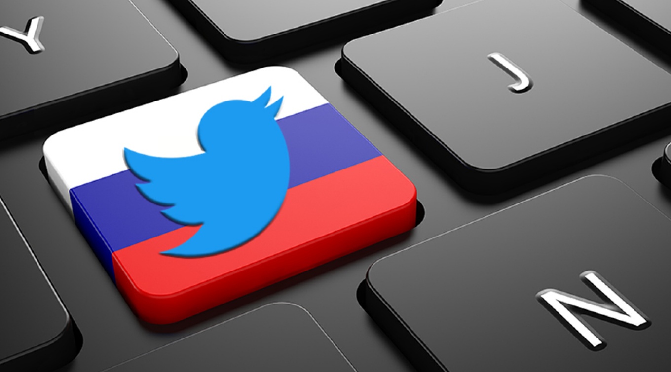 A computer keyboard with one key that features the colors of the Russian flag and the Twitter bird logo. 