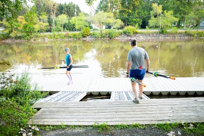 Zoom image: Barnum (right) carries oars to the dock with friend and rowing mate Elizabeth Ostermeier-Denecke. Photo: Meredith Forrest Kulwicki 