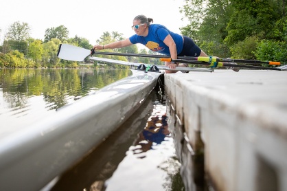 Zoom image: Barnum secures the oars in place on her scull. Photo: Meredith Forrest Kulwicki 