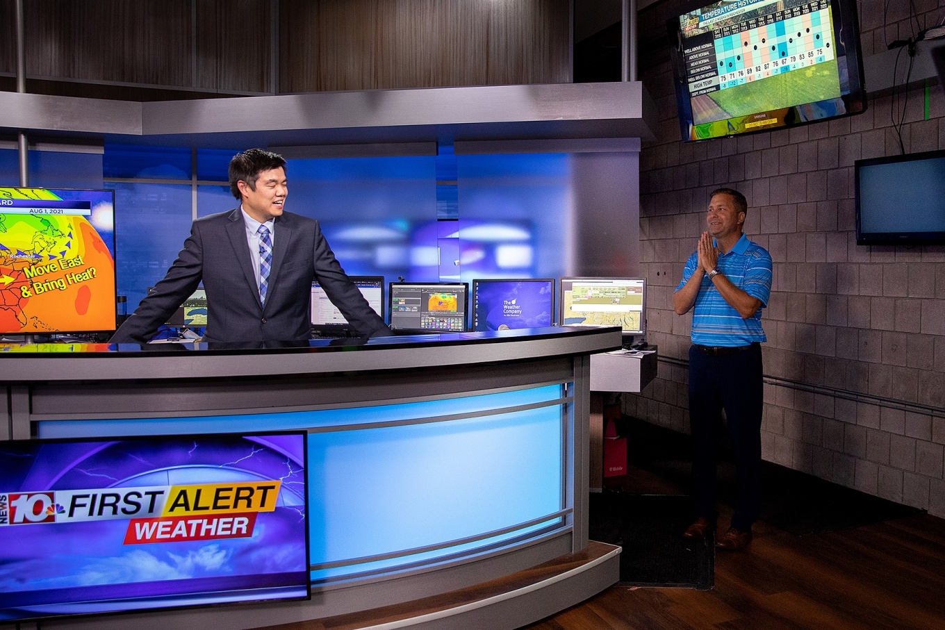 Zoom image: A WHEC co-worker stops by to ask about the weekend weather to see if it will impact his plans. 