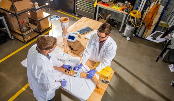 Zoom image: Garwood Medical Devices’ Tim Kopera, engineering manager, and Jackson Hobble, biomedical engineer and a UB alumus, demonstrate the BioPrax™ technology. Photo: Douglas Levere 
