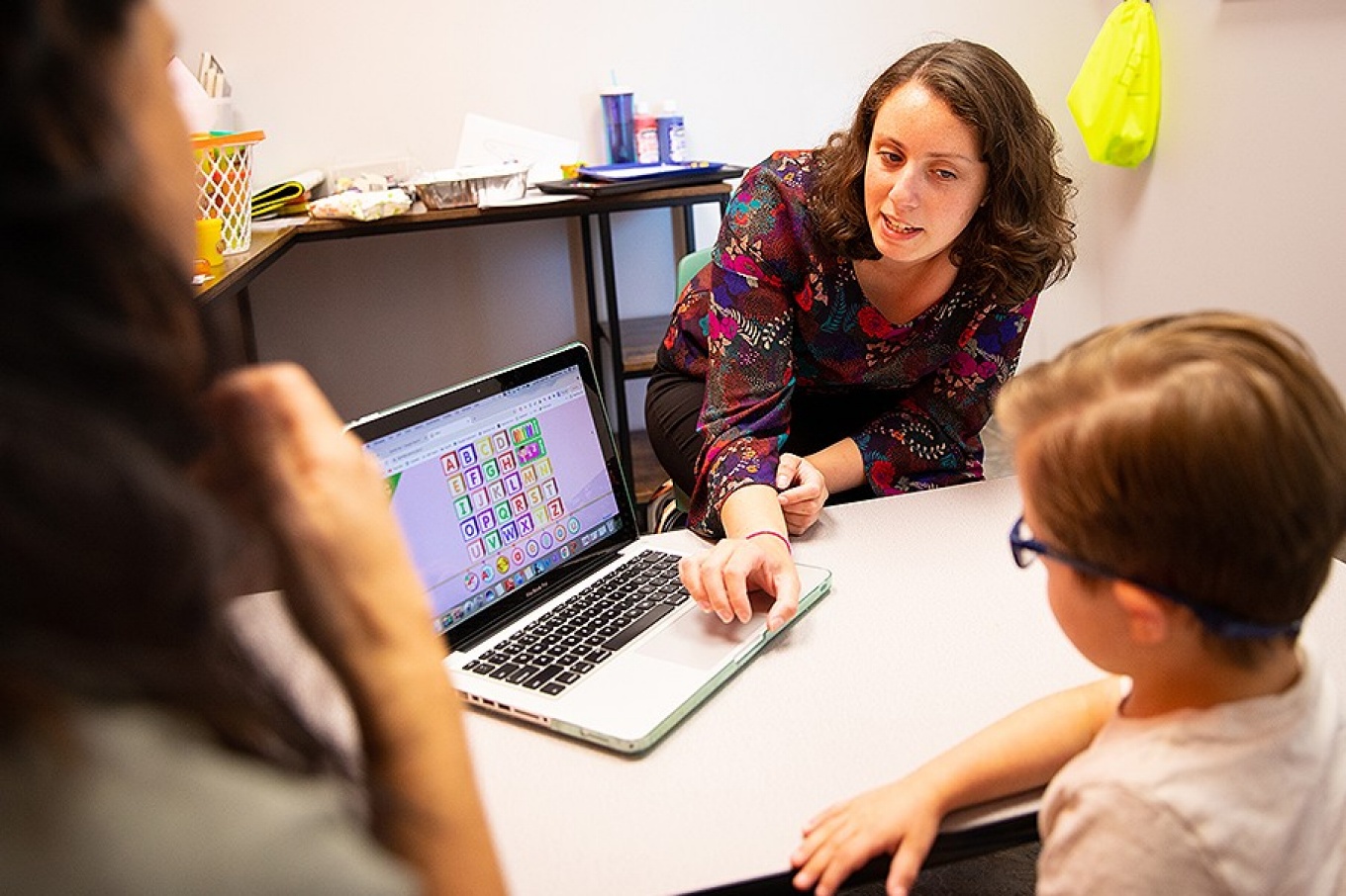 Zoom image: Master's student Maria Priore (right) works with a student, while Emily Mondschein (far left), a parent and executive director of GiGi’s Playhouse Buffalo, watches the lesson. Photo: Meredith Forrest Kulwicki 