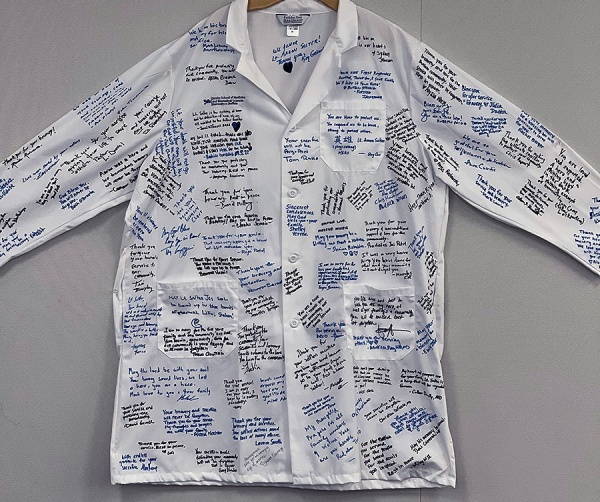 Zoom image: More than 130 members of the Jacobs School community signed the white coat over two days this week. Photo: Jamal Williams 