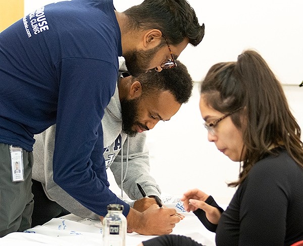 Zoom image: Jacobs School students sign the white coat. Photo: Sandra Kicman 