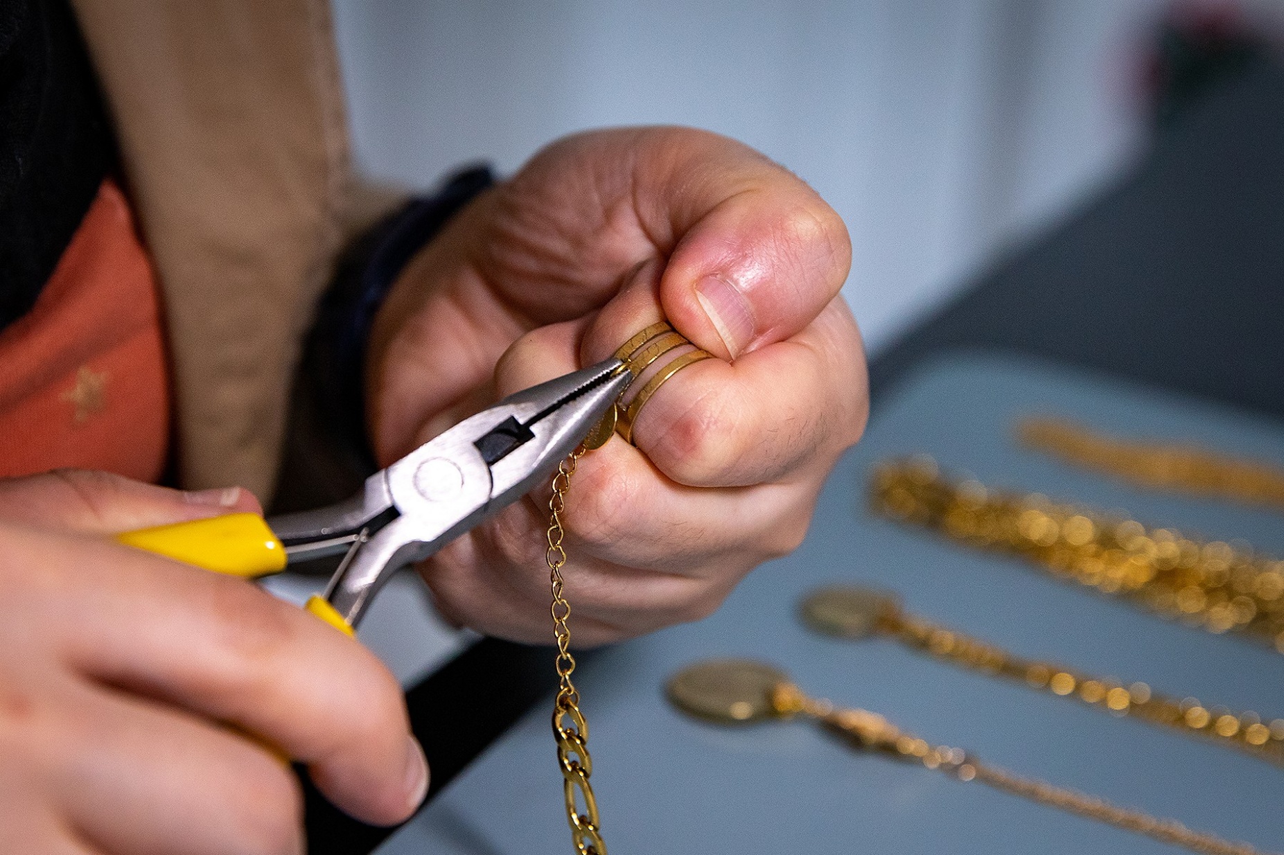 Zoom image: Aref uses a specially designed ring called a Beadsmith jump ring opener to make the fine adjustment to the claps and chains while crafting her jewelry. 