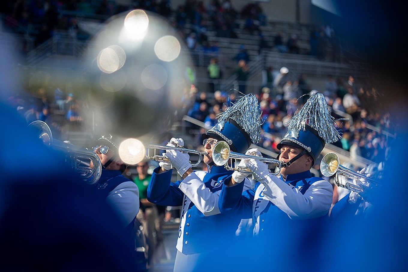 Trumpet players from the UB marching band on the football field.
