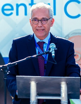 Stefan Ruhl speaking from a podium during new dental van ribbon cutting ceremony. 